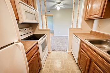 A kitchen with white appliances and wooden cabinets